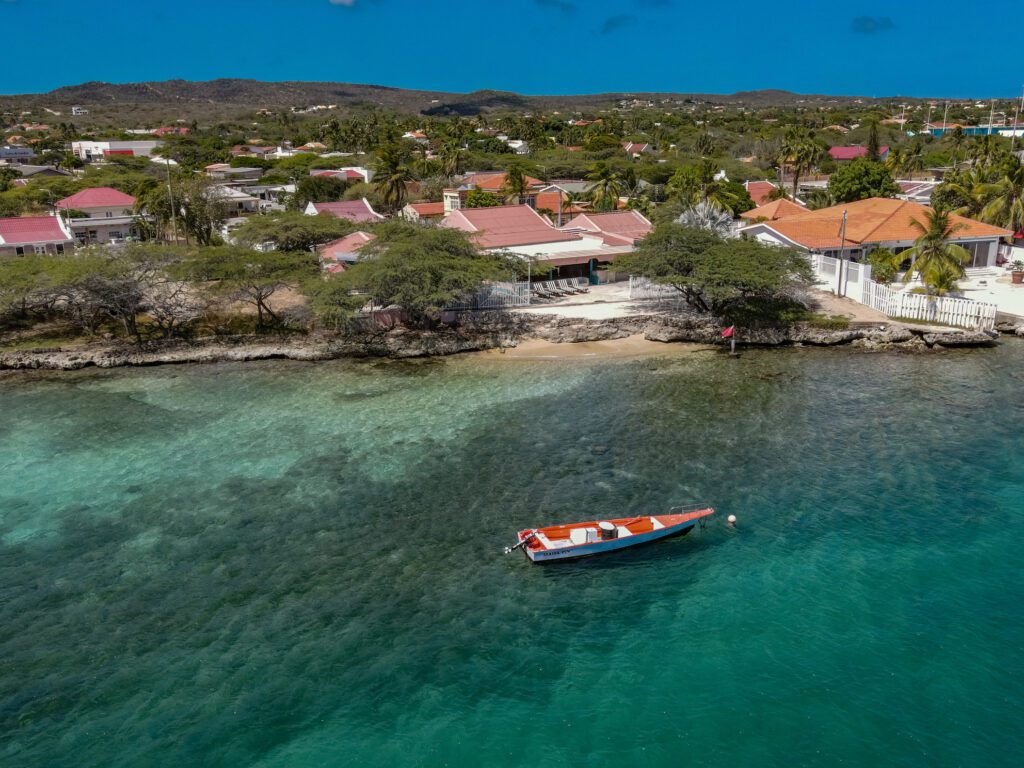 Clear turquoise water along the Savaneta coast on Aruba's sheltered south side, with a small fishing boat at anchor