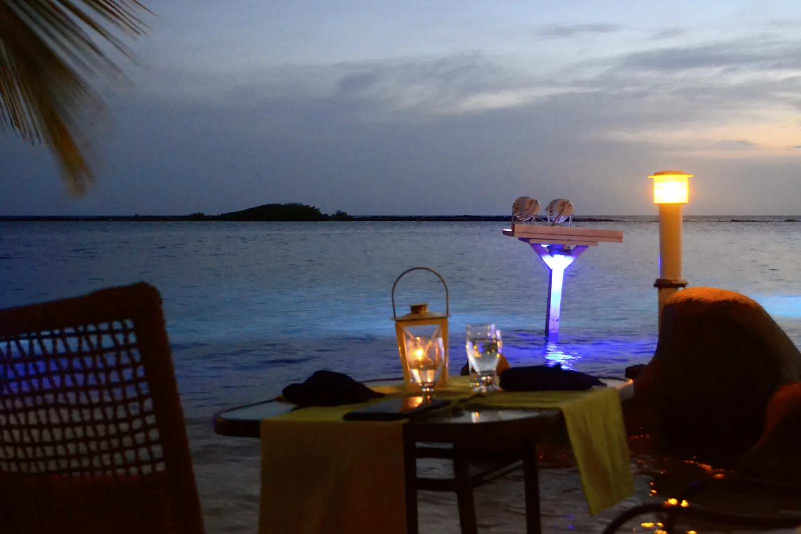 Candlelit table at the water's edge at sunset at The Flying Fishbone in Savaneta, Aruba