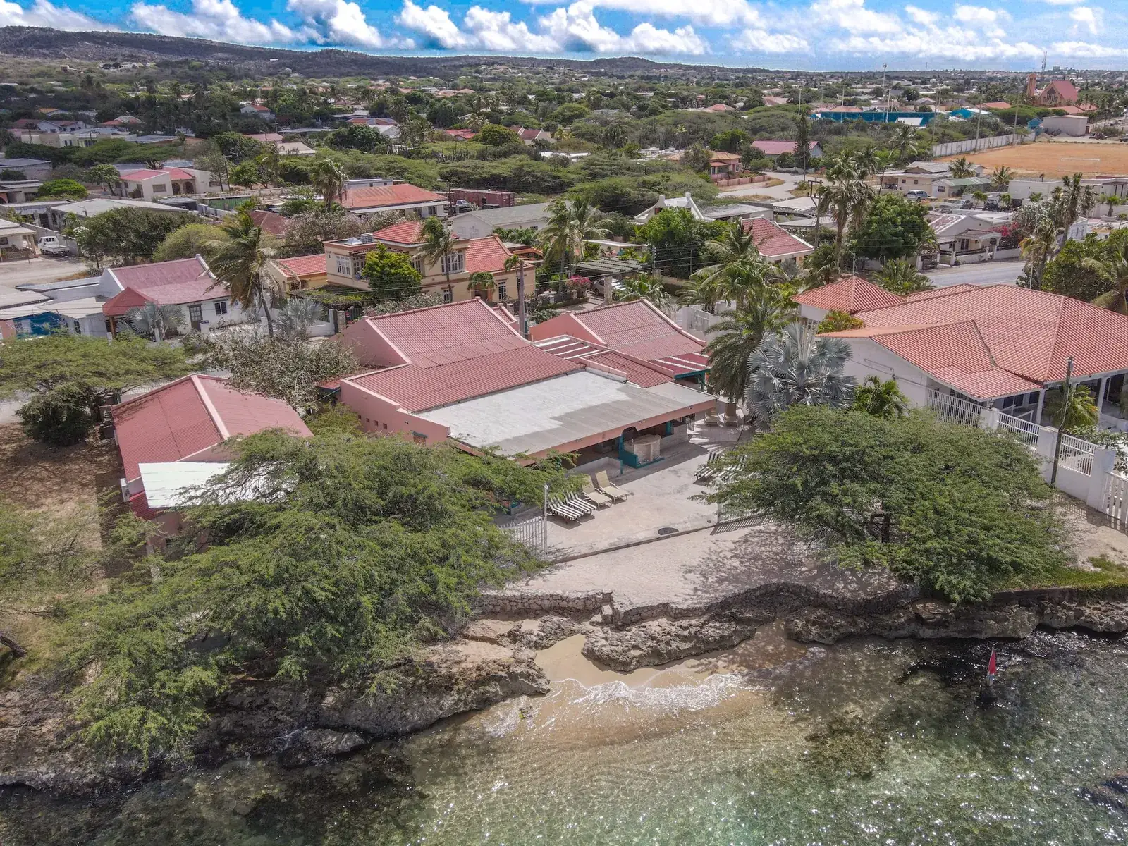 Aerial view of Peachy Beach in Savaneta, Aruba: the villas, a small sandy beach and the clear, shallow bay in front of it