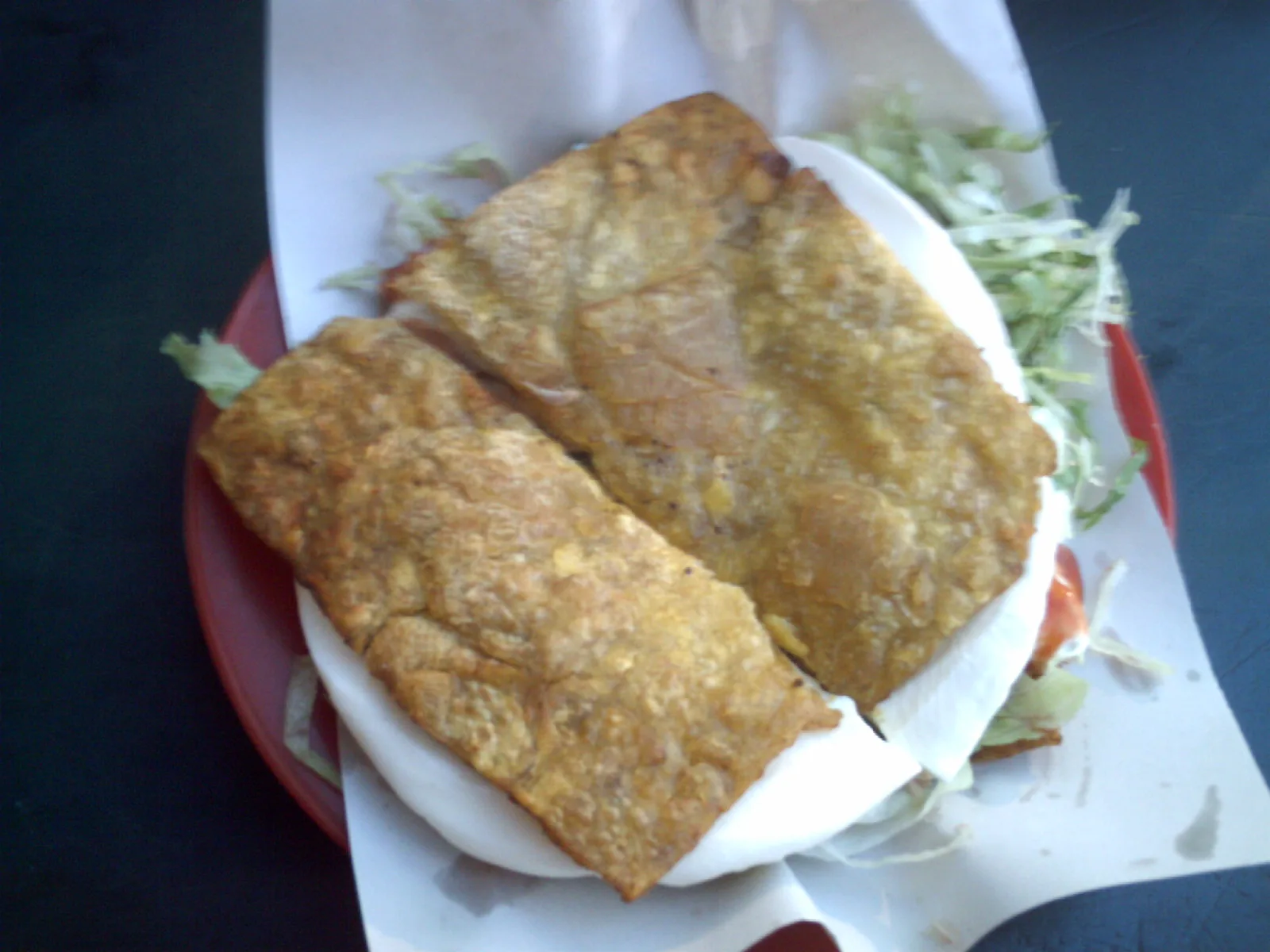 A Venezuelan-style patacón sandwich made with fried plantain slabs, cheese and vegetables