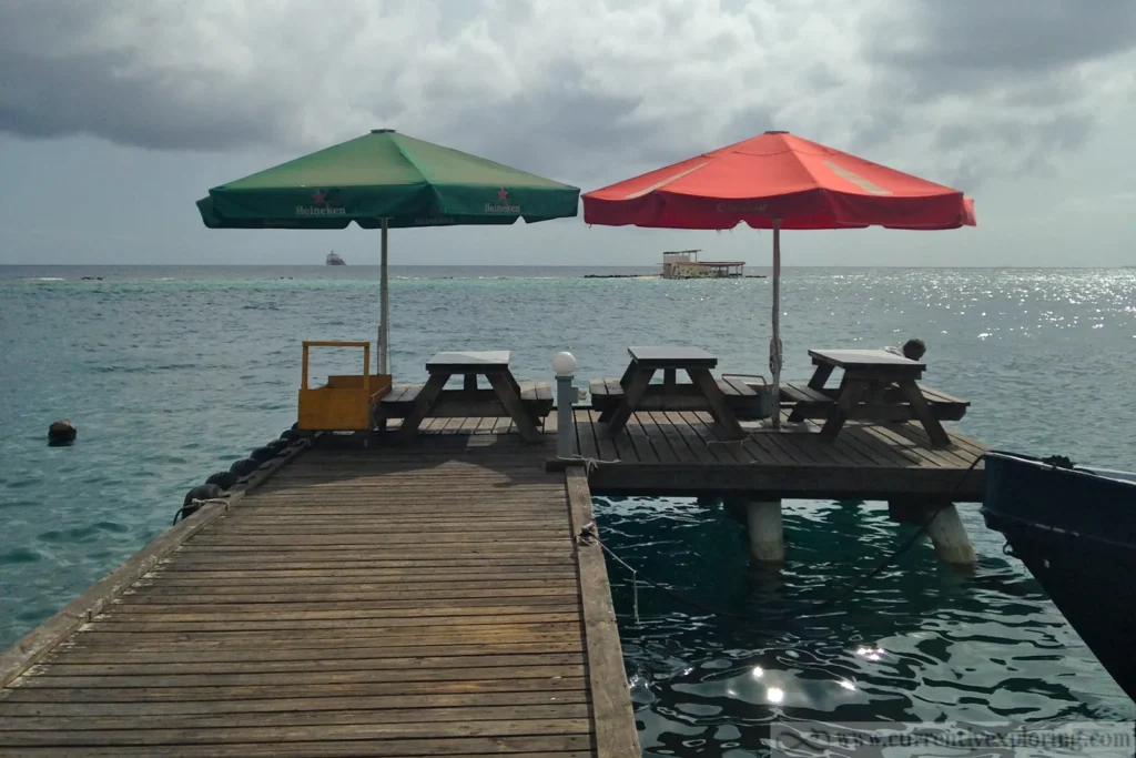 The Zeerovers dock in Savaneta, Aruba, with picnic tables and umbrellas over the water